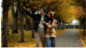 A couple walking along a scenic path lined with golden autumn trees, showcasing one of the best places to visit in November for fall foliage.